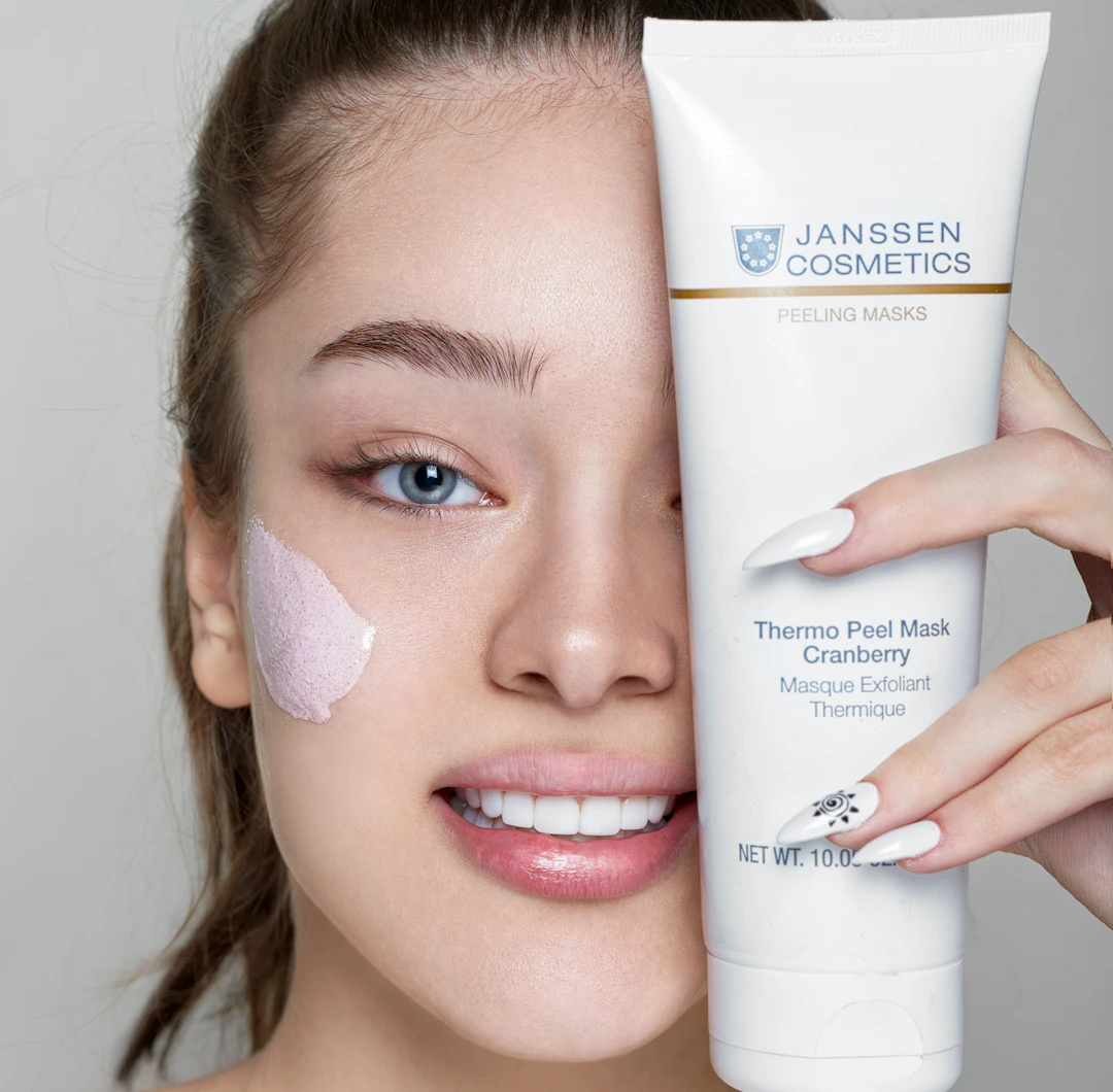 Close-up of a smiling middle-aged woman with smooth, glowing skin holding a jar of Vitalysse Beetox cream.